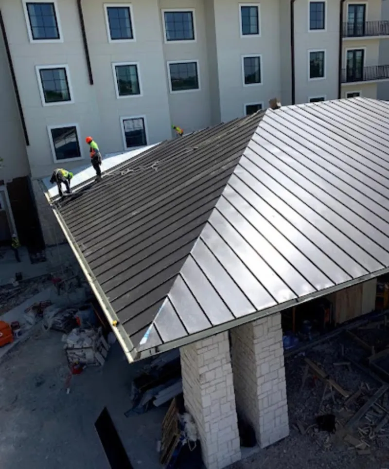 Crew installing standing seam metal roof panels on a commercial project in Stroudsburg